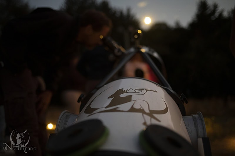 Telescopio observando la luna en una actividad de observación astronómica